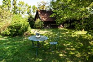 una mesa y sillas en un patio con una casa en Manoir-de-Sagy, en Sagy