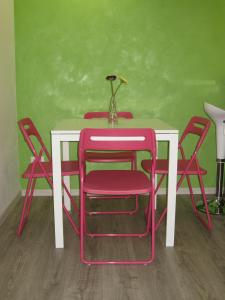 パレルモにあるBed & Breakfast Amari 58の赤い椅子と花瓶が置かれた白いテーブル