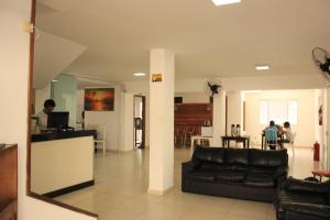 Una sala de estar con un sofá negro y una mesa. en Novo Hotel Douglas, en Balneário Camboriú