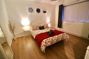 1 dormitorio con 1 cama con edredón rojo en Glenwell House, en Newtownabbey