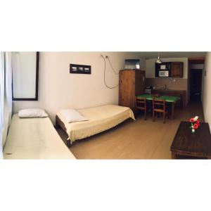 Una pequeña habitación con dos camas y una mesa. en Der Mar, en Villa Gesell