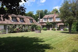 uma casa grande com um quintal com relvado em Cottage Normand em Montaure