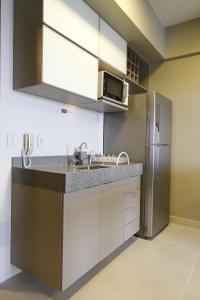 a kitchen with a sink and a refrigerator at #2 Sofisticado Estúdio na Boaventura da Silva in Belém