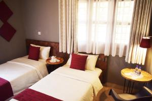 a hotel room with two beds and a window at Mahali Guesthouse, Makindye Hill in Kampala