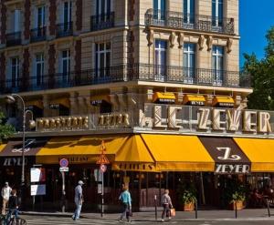 a building with yellow umbrellas on a city street at Belleza Relax et Grand Repos in Paris