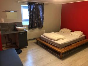 um pequeno quarto com uma cama e um lavatório em La trinite em Gérardmer