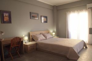 a bedroom with a bed and a desk and a chair at Ideally Situated Corfu Old Town Studio in Corfu Town