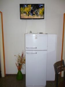einen weißen Kühlschrank in einem Zimmer mit einem Bild an der Wand in der Unterkunft Nuestro refugio en Mendoza in Mendoza
