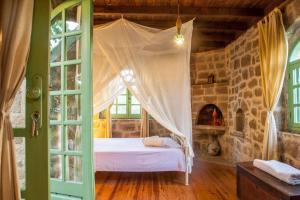 a bedroom with a bed in a room with a fireplace at Oliveyard Stone Built House- with pool non chlorin in Koskinou +83 photos