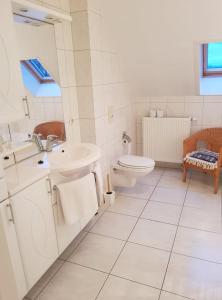 La salle de bains blanche est pourvue d'un lavabo et de toilettes. dans l'établissement Hotel-Cafe Knoors-Meeks Stein Urmond, à Berg