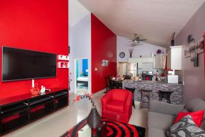 uma sala de estar com uma parede de acento vermelho em The Oasis II, Caymanas Country Club em Ellis Caymanas