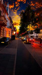 a city street at sunset with cars parked on the street at A&S FerienwohnungenBonner str 49 in Bonn