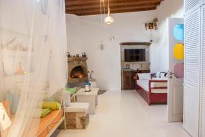 a living room with a fireplace and a couch at Oliveyard Stone Built House- with pool non chlorin in Koskinou
