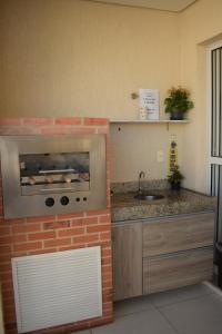 a kitchen with a brick oven and a sink at Mediterrâneo 507 - Todo Equipado, Ar Condicionado, Churrasqueira na Varanda, Internet Fibra 600MB, Estacionamento Grátis in Cabo Frio