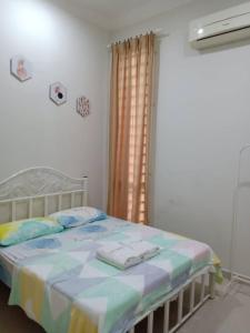 a bedroom with a bed with towels on it at Ajmal Homestay @ Kota Bharu in Kota Bharu