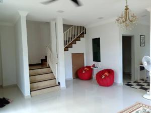 a living room with two red chairs and a staircase at Ajmal Homestay @ Kota Bharu in Kota Bharu