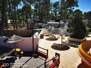 un patio con sombrillas, sillas y mesas en Mobil home de 44m2, en La Palmyre