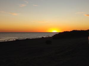 einen Sonnenuntergang am Strand mit Sonnenuntergang in der Unterkunft Valle Encantado in Monte Hermoso