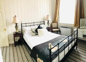 a bedroom with a bed and two lamps and a window at Alexander House in Corsham