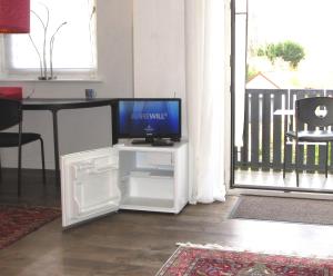 a tv sitting on a white stand in a living room at Gästezimmer im Hamburger Norden - nahe EuroFH und ILS in Hamburg