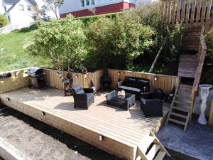 a wooden deck with furniture and a grill at Apartments-BnB in Sørvágur