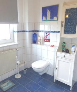 een badkamer met een wit toilet en blauwe tegels bij Gästezimmer im Hamburger Norden - nahe EuroFH und ILS in Hamburg