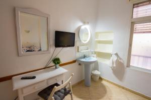łazienka z umywalką i lustrem w obiekcie Hostal Guillot w mieście Torremolinos