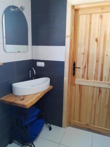 a bathroom with a sink and a mirror and a door at Domek u Jawora -Agroturystyka in Grywałd