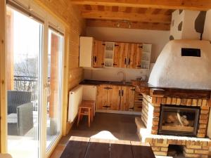 a kitchen with a fireplace in a log cabin at Domek u Jawora -Agroturystyka in Grywałd