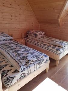 two beds in a log cabin with at Domek u Jawora -Agroturystyka in Grywałd