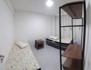 a room with two bunk beds and a table at Apartamento Braga in Cabo Frio