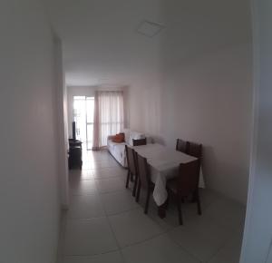 a dining room with a white table and chairs at Apartamento Braga in Cabo Frio