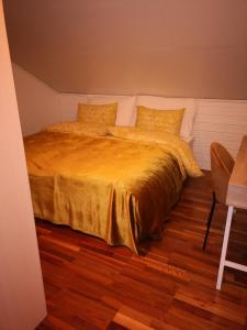 a bedroom with a bed with a yellow blanket at Goldin in Kautokeino