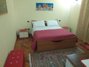 B&B Villa Roberta في فِتيربو: غرفة نوم بسرير كبير مع بطانية ارجوانية