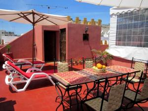 patio con tavolo, sedie e ombrellone di Dar Yanis a Rabat