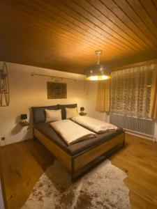 a bedroom with a bed with a wooden ceiling at Haus Simmering in Obsteig