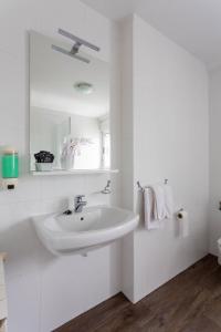 a white bathroom with a sink and a mirror at Hotel Canaima Bruma 1,5 k Camino in O Mesón Do Vento 