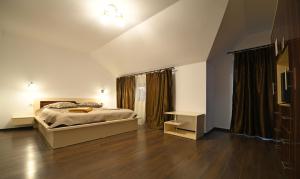 a bedroom with a bed and a wooden floor at Pensiunea Natalia in Toteşti