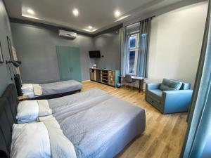 um quarto com 2 camas, um sofá e uma cadeira em K43 Rooms em Belgrado