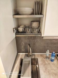 un bancone cucina con lavandino e alcuni piatti di E-Milan Rooms Zona Tortona a Milano Altre 43 foto