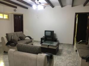 a living room with two couches and a tv at Villa High Town Al Shuruq City in Madīnat ash Shurūq