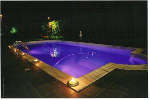 una piscina notturna con illuminazione viola di Hotel Ristorante Il Gambero a Porto SantʼElpidio