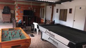 a ping pong table in a living room with at Hostal Villa Aurora in Roldanillo