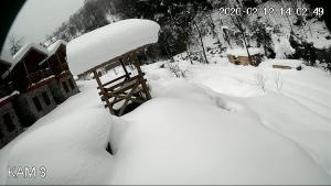 un patio cubierto de nieve con un alimentador de aves en Mencuna Konaklari, en Arhavi