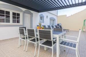 a dining table and chairs on a patio at Villa Coracao Jacuzzi - 200m Beach & Sea View in Albufeira