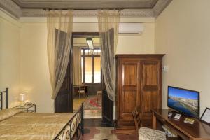 a bedroom with a bed and a desk and a tv at B&B Antica Piazza dei Miracoli in Pisa