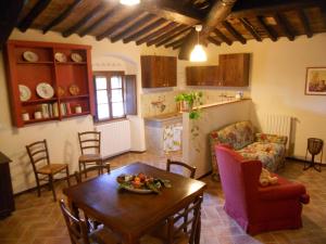a kitchen and living room with a table and chairs at Podere Pian dei Gelsi in Volterra