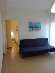 un soggiorno con divano e una bicicletta appesa al muro di Vanessa's Rooms & Apartments a Kanali
