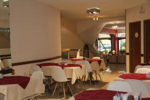 a restaurant with tables and white chairs and a staircase at Alpino Hotel in Buenos Aires