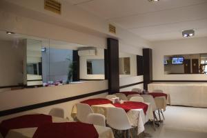 - une salle à manger avec une table, des chaises et des miroirs dans l'établissement Alpino Hotel, à Buenos Aires